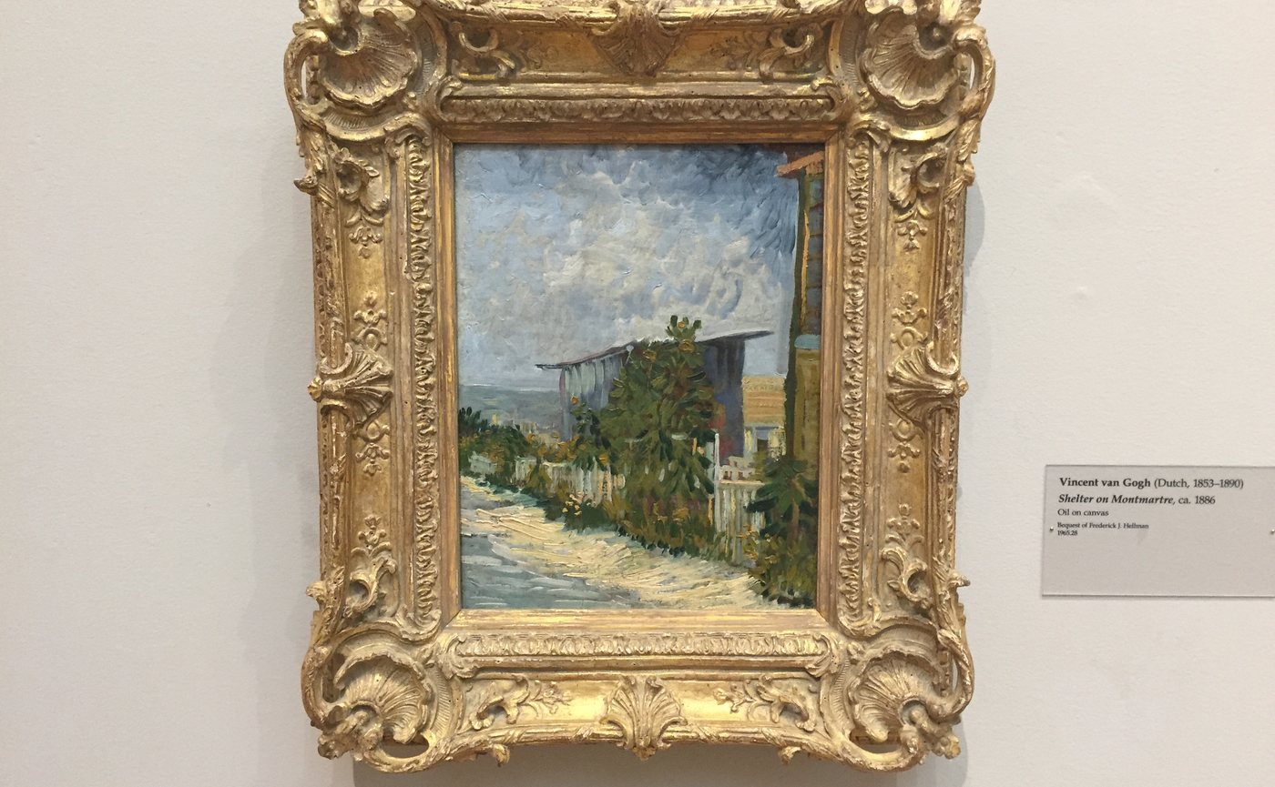 A painting of a house among trees by Van Gogh, in a gold frame