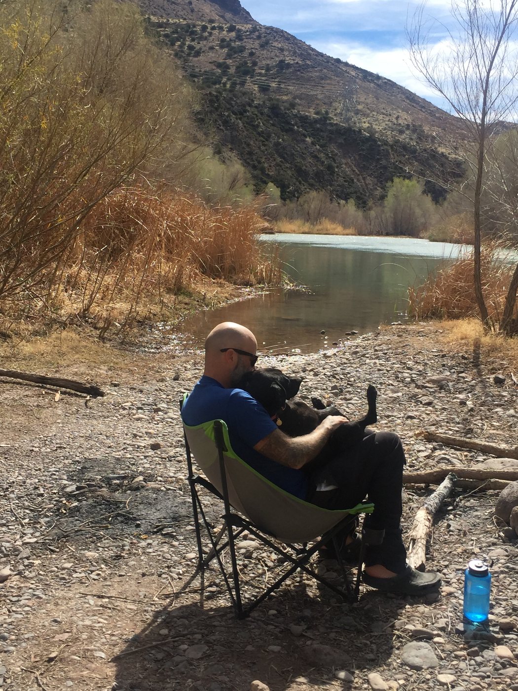 Mark in a camp chair by the Verde River with Charlie on his lap