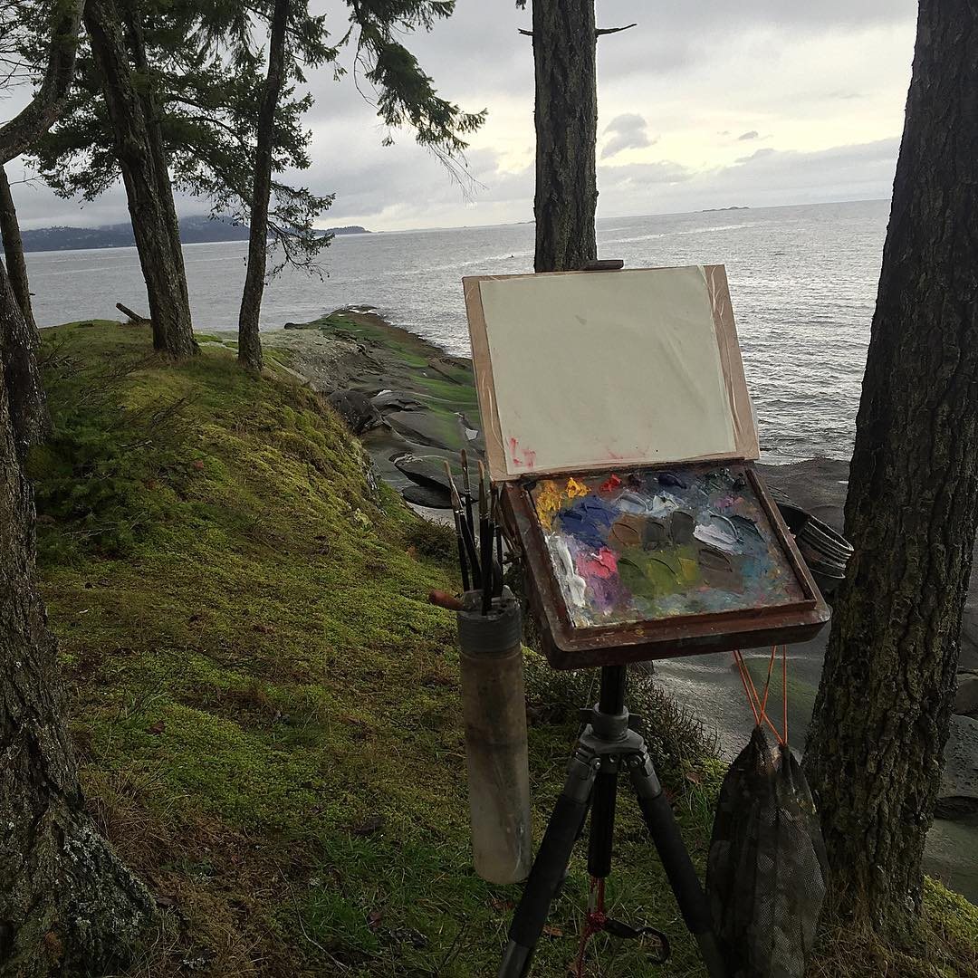 The small red cigar-box easel on a tripod on a mossy point above the sea