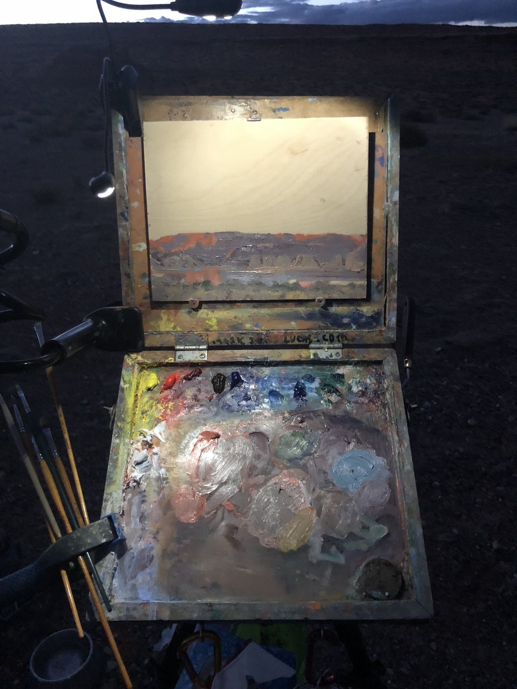 The pochade box at night with a small light on the panel and palette