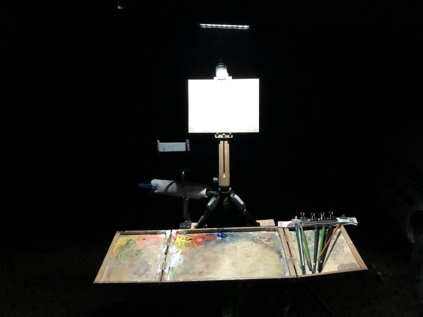 The fold-out easel at night, a bright LED bar above a white panel, the palette lit below
