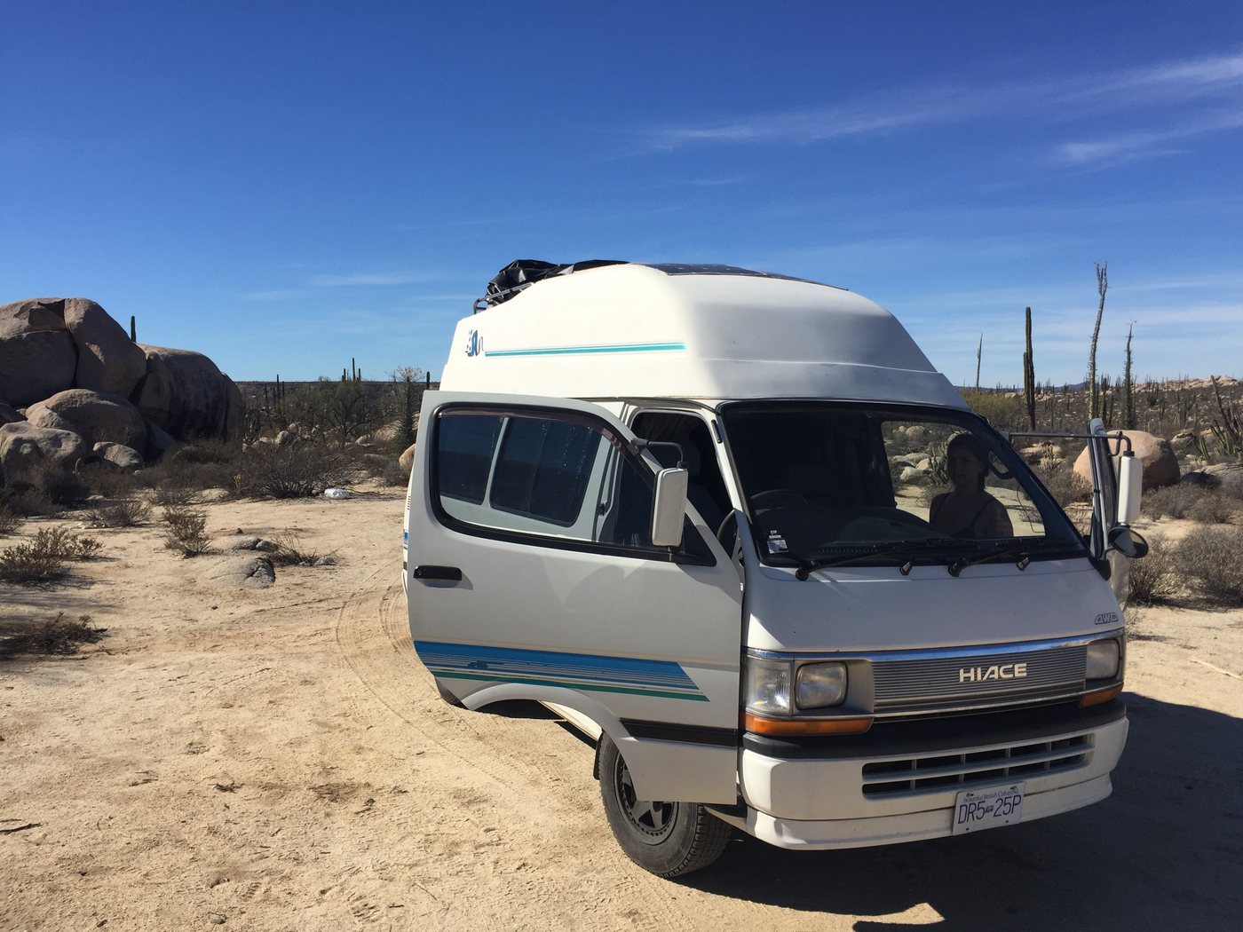 The van among boulders and cardón cactus in the Baja desert