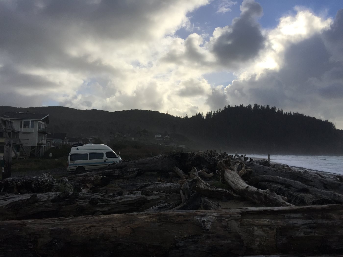 The van parked by driftwood on the Oregon coast under heavy cloud