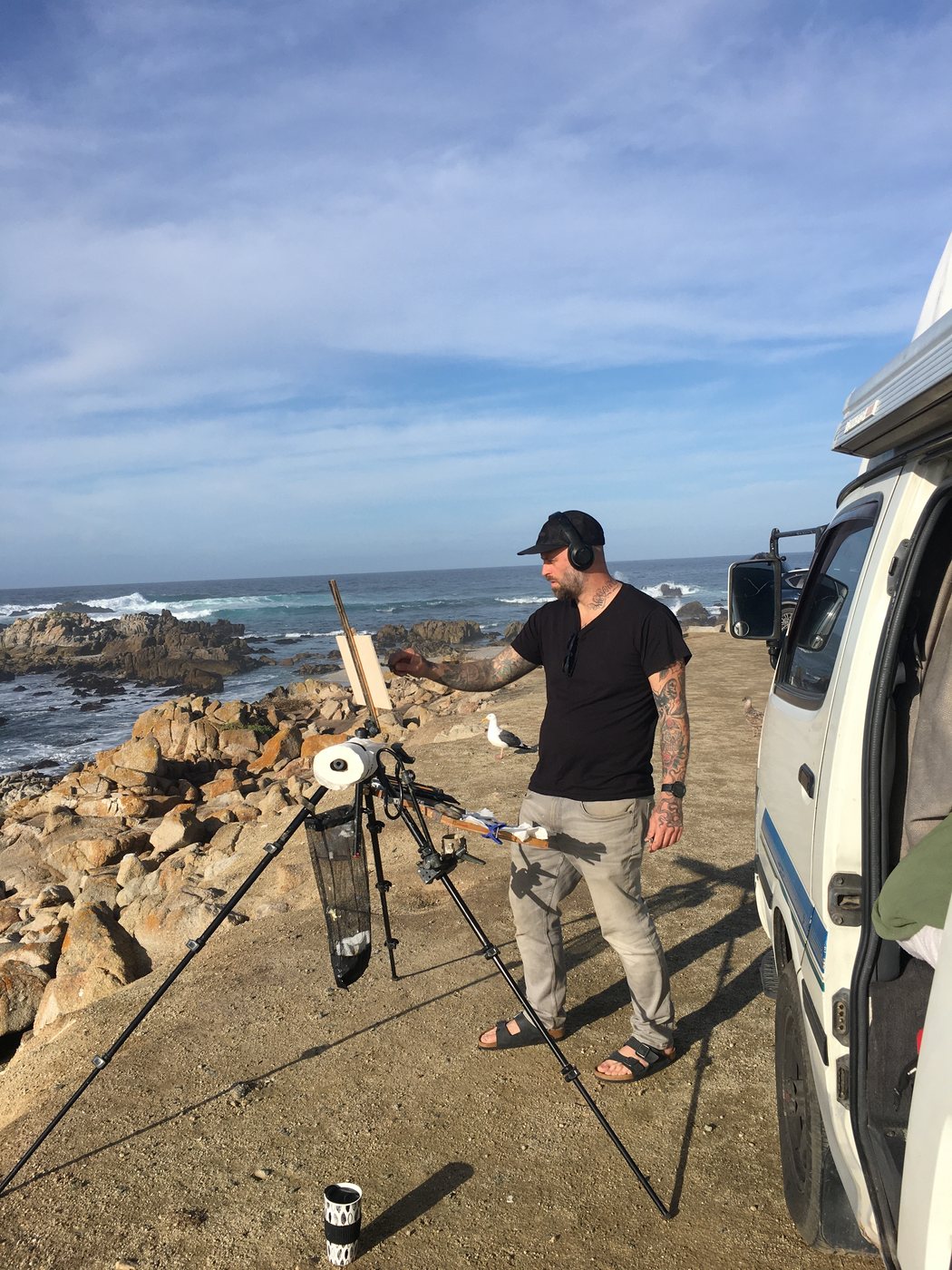 Mark at his easel on the rocks beside the van at Pacific Grove